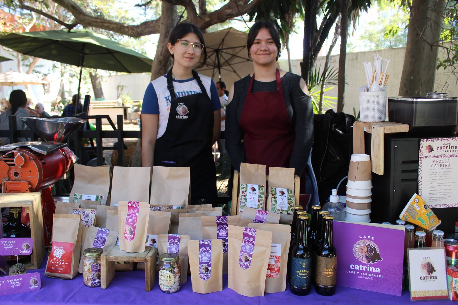 Equipo de Café Catrina en su puesto, con mandiles de la marca y bolsas de café tostado