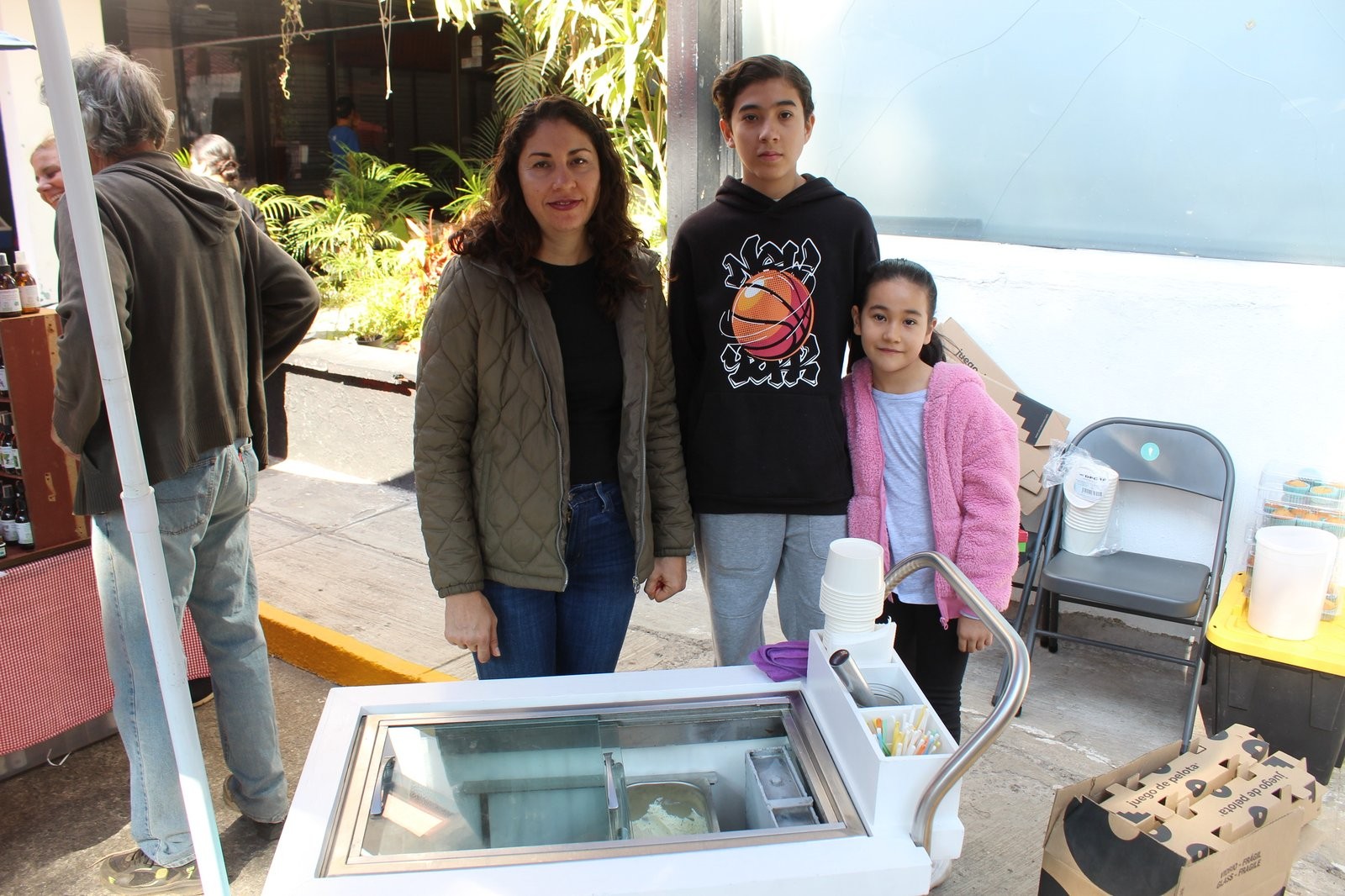 Beatriz García Ríos junto a sus dos hijos, en el puesto de GelatoLand con el carrito de gelato