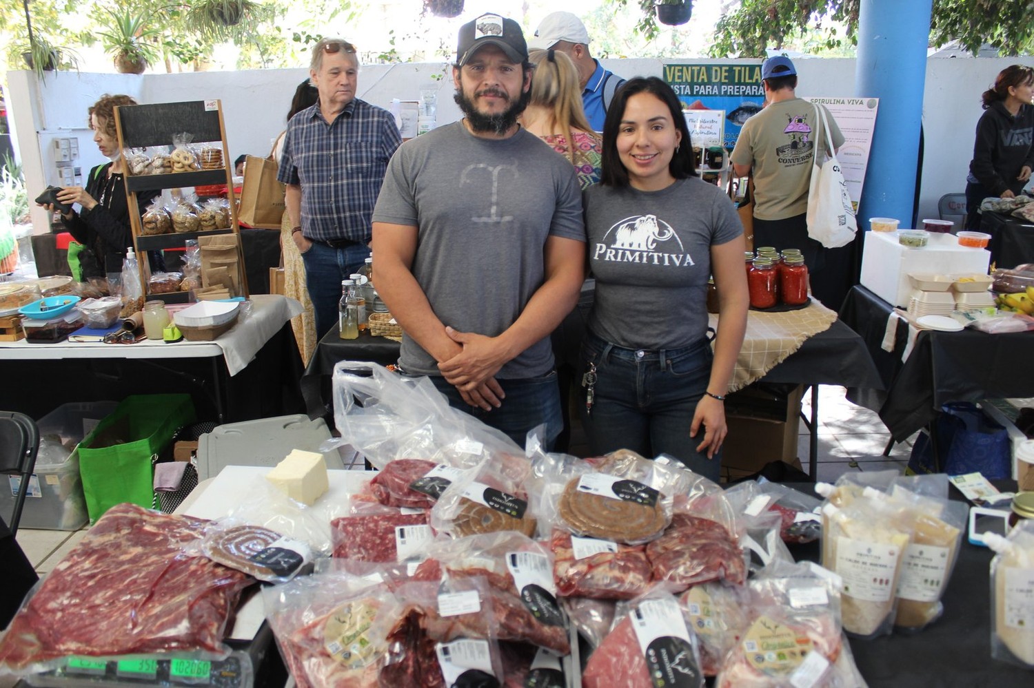 El equipo de Indomitus en su puesto, con cortes de carne empacados, chorizo y queso sobre la mesa
