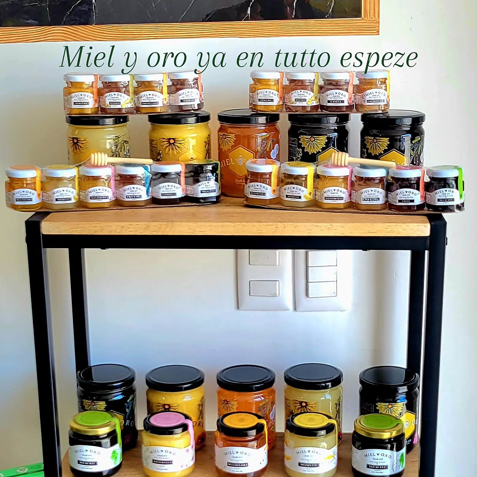 Estante con decenas de frascos de miel y productos de Miel Oro, en variedades como cúrcuma, canela, cafetal y mantequilla